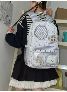 Ins Stil großer Rucksack mit grauem Sternenmuster, transparenter Vordertasche und Plüschtier.