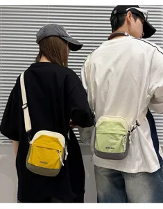 Detail shot of the lightweight contrast color crossbody phone bag worn by models.