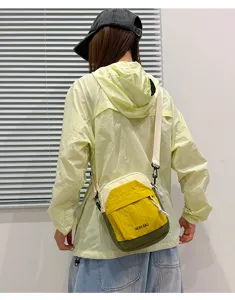 Detail view of the lightweight color-blocked crossbody phone bag, showing fabric texture and zippers.