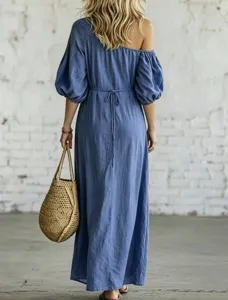 Back view of blue off-shoulder puff sleeve maxi dress with waist tie and straw bag in detail.