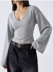 Detail shot of grey V-neck top featuring trendy flared bell sleeves and soft fabric.