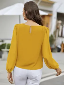 Back view detail of elegant mustard yellow long sleeve blouse with keyhole button design.