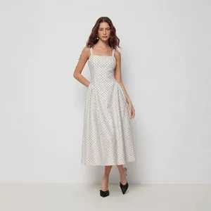 Detailed view of a retro polka dot midi dress featuring a square neckline, straps and A-line skirt.