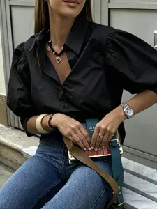 Close-up detail of the black puff sleeve shirt featuring classic lapel and chic button front.