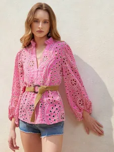 Detail view of pink eyelet embroidered long-sleeve blouse with V-neck and stylish lantern sleeves.