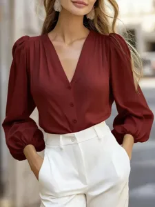 Close-up detail of elegant French V-neck lantern sleeve solid color blouse in burgundy.