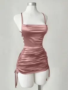 Close-up of ruched satin camisole mini dress detail, showcasing adjustable side drawstrings.