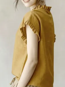 Nahaufnahme Detail mit dem eleganten Rüschenkragen und ärmeldesign der modischen Bluse.