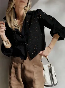 Detailed view of black eyelet embroidered short blouse, showcasing delicate hollow-out patterns.