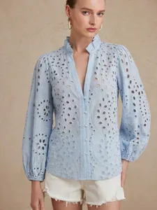 Detailed view of the light blue eyelet embroidered blouse featuring a chic ruffled stand collar.