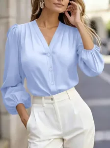 Elegant light blue V-neck lantern sleeve blouse with white office trousers for women.