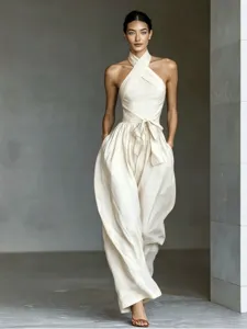 Elegant halter neck cross-over jumpsuit featuring high waist tie and wide lantern legs style.