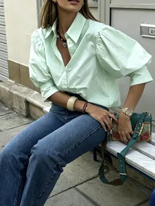 Close-up detail of light green puff sleeve casual shirt with elegant lapel design.
