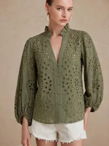 Detail view of olive green eyelet embroidered blouse with lantern sleeves and V-neck.