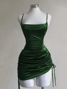 Detail shot of the dark green satin ruched bodycon dress, showing the side drawstring.
