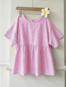 Close-up detail of the pink vertical striped blouse, featuring a loose A-line hem and short sleeves.