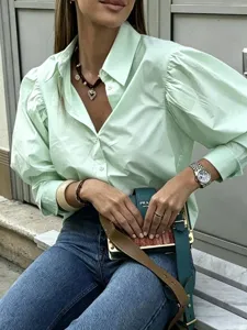 Close-up detail of light green puff sleeve casual shirt with lapel and button design.