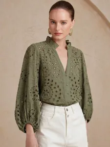 Detailed view of the olive green eyelet embroidered blouse with lantern sleeves and ruff collar.