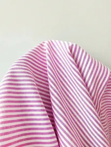 Close-up detail shot of pink and white vertical striped fabric, showcasing fine texture.