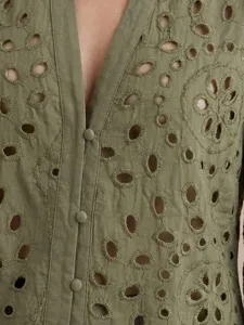 Olive green V-neck shirt detail showing intricate eyelet embroidery and button front design.