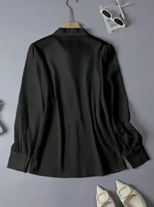 Black long sleeve draping blouse detail, elegant commuting style, smooth fabric texture.