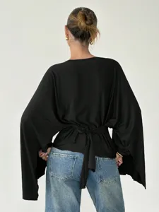 Stylish women's black long sleeve flared batwing blouse with back tie detail casual top