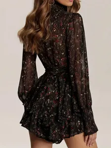Détail de dos de la robe noire à fleurs, manches longues, taille haute et volants élégants.