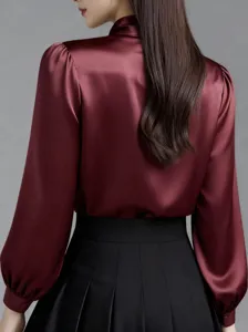 Maroon satin blouse featuring long puff sleeves and pleated skirt back view detail.