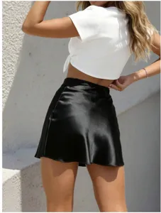 Details of stylish black satin mini skirt, showing the sleek fabric texture and elegant fit.