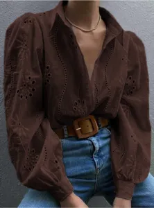 Detailed view of the dark brown hollow embroidered blouse featuring chic puff sleeves and lapel.