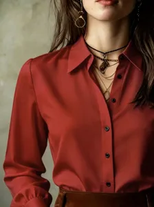 Chic red long-sleeve button-down shirt detail showing collar, lantern sleeves and buttons.