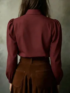 Detail shot of the elegant long sleeve button-up blouse with puff sleeves in dark red.