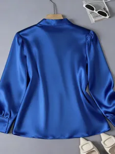 Detailed view of blue satin blouse, elegant long sleeves, smooth texture, professional style.