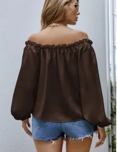 Brown off-shoulder long sleeve blouse with ruffled neckline and blue denim shorts detail.