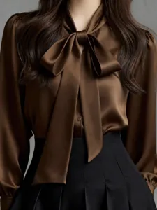 Elegant brown satin long sleeve blouse with bow tie detail, perfect for chic professional workwear.