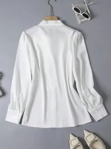 Detailed shot of white long sleeve blouse, smooth draped fabric, elegant commuting top.