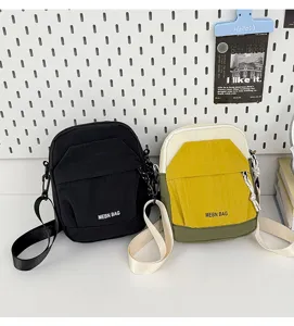 Detail view of casual color block cross body mobile phone bag with adjustable strap and zip pocket.
