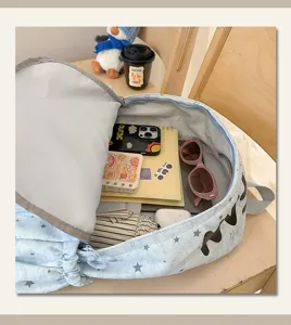Detail view of cute blue star print schoolbag showing large capacity interior with daily items.