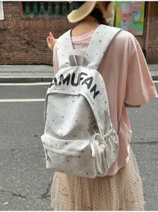 Detail shot of a casual grey star print backpack worn outdoors, showcasing design and fabric.