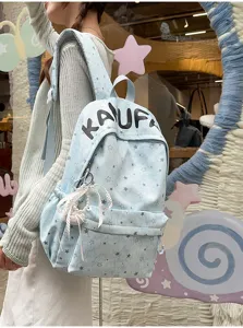 Backpack detail shot showing stylish blue star print fabric and cute pearl bow pendant.