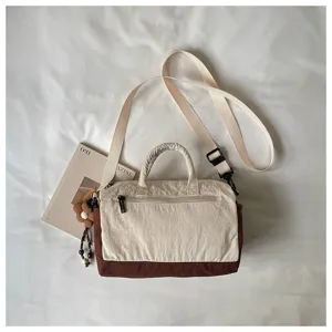Borsa a tracolla in tela in stile coreano con design bicolore e manico superiore.