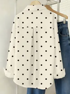 Detailed white long-sleeve button-down shirt featuring chic black polka dots detail.