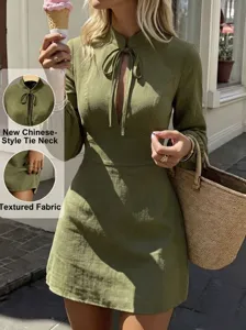Close-up details of the new Chinese style tie-neck long sleeve green mini dress texture.
