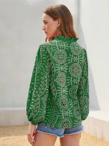 Green embroidered floral hollow out long sleeve shirt detail view showing fabric texture.
