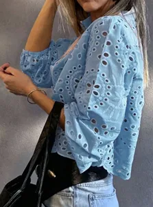 Blue eyelet embroidered blouse sleeve detail showing delicate hollow design and bubble sleeves.