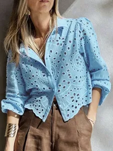 Detail view of the light blue eyelet embroidered cropped shirt, showing breathable fabric design.