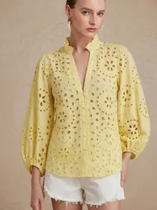 Close-up details of the elegant yellow eyelet embroidered long sleeve blouse with ruffled collar.