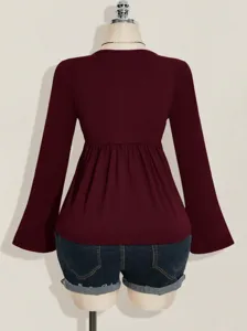 Burgundy long sleeve blouse back view detail showing slim fit and flared pleated hem design.