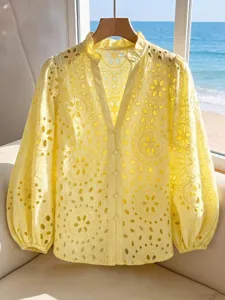 Detail shot of the yellow hollow out embroidered lantern sleeve blouse with stand collar.