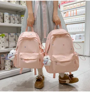 Gros-plan du joli sac à dos rose de style japonais avec broderie d'étoiles et de lune.